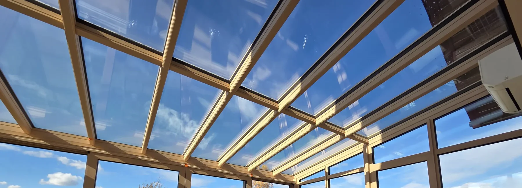 Lichtdurchflutete Aluminium-Glaskonstruktion mit Blick in den Himmel